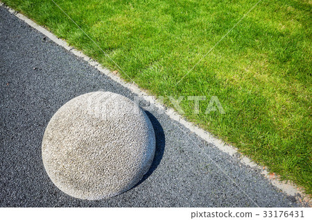 Asphalt floor, lawn and hemisphere barrier. 33176431