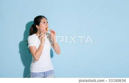 attractive female student standing on blue wall attractive female student standing on blue wall 33180636