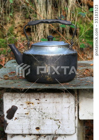 Worn teapot on old stove 33183523