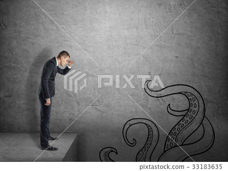 A businessman on grey concrete background looks A businessman on grey concrete background looks 33183635
