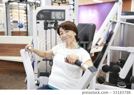 Elderly woman doing machine training in a sports club Elderly woman doing machine training in a sports club 33183786