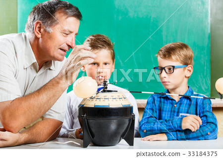 Two schoolboys and their teacher in class 33184375