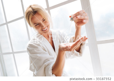 Amazing girl looking at her cosmetics in drops Amazing girl looking at her cosmetics in drops 33187352