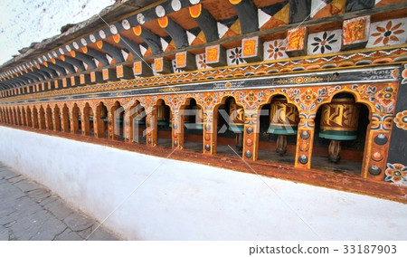 Rows of colorful religious prayer wheels in Bhutan 33187903