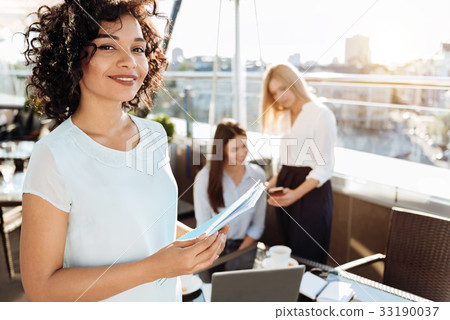 Joyful attractive woman holding documents 33190037