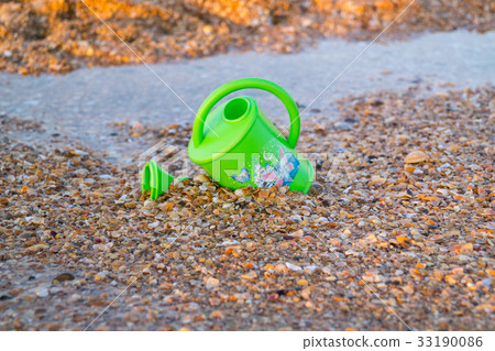 Children toy for watering flowers on the beach Children toy for watering flowers on the beach 33190086