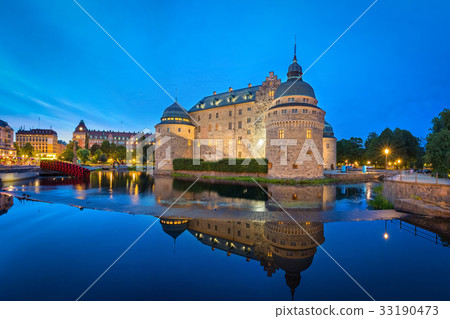 Orebro Castle reflecting in water in the evening 33190473