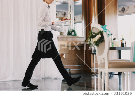Waiter walks across the restaurant hall 33191029