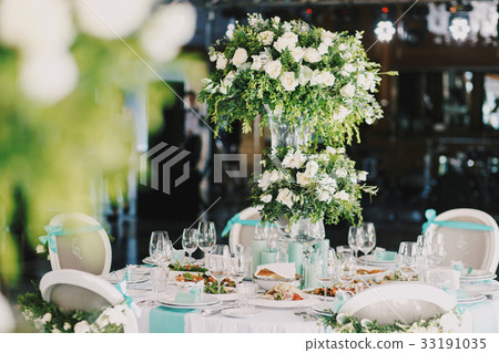 Rich bouquet of roses stands on the dinner table Rich bouquet of roses stands on the dinner table 33191035