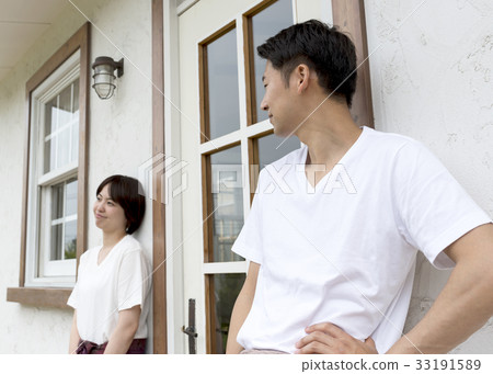 A couple wearing relaxed wear standing in front of the house 33191589