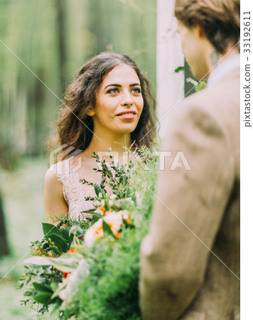 The blurred shoulder of the standing groom in 33192611