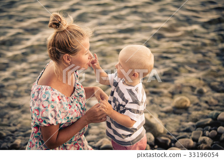 Son touches my mother's nose at the seashore 33196054