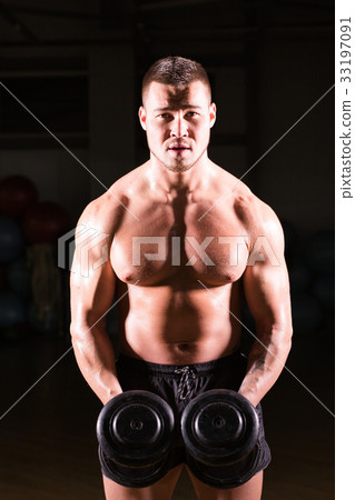 Athletic shirtless young male fitness model holds Athletic shirtless young male fitness model holds 33197091