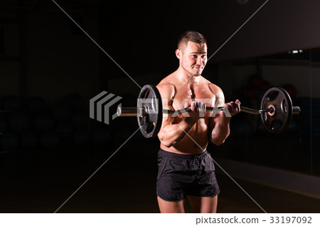 young man doing heavy weight exercise for biceps. young man doing heavy weight exercise for biceps. 33197092