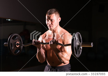 Muscular man working out in gym doing exercises Muscular man working out in gym doing exercises 33197093
