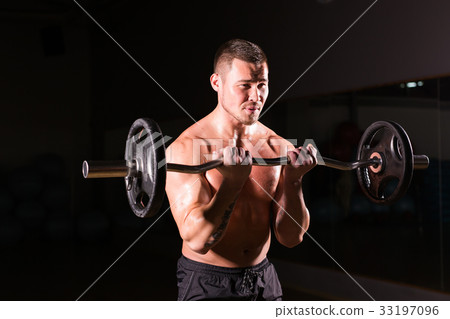 young man doing heavy weight exercise for biceps. young man doing heavy weight exercise for biceps. 33197096