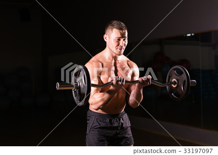 Confident muscular man training with barbell Confident muscular man training with barbell 33197097