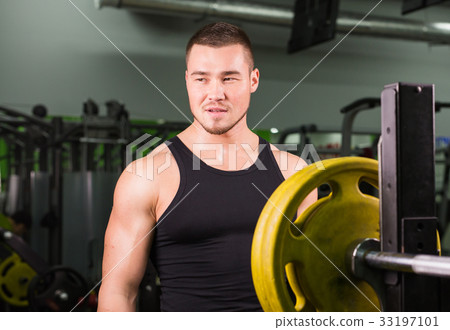 Young healthy man with big muscles holding disk 33197101