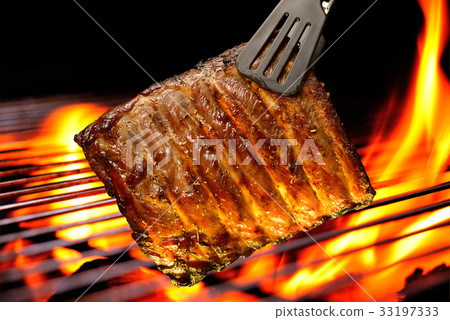 Grilled pork ribs on the flaming grill Grilled pork ribs on the flaming grill 33197333