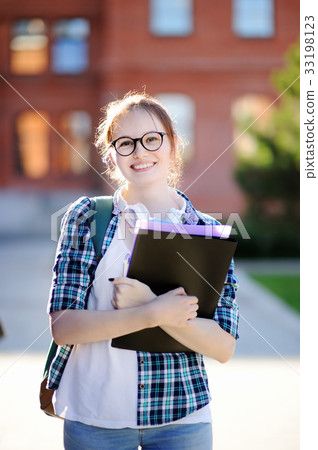 Young student girl with books and notes outdoors Young student girl with books and notes outdoors 33198123