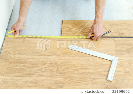 Installation of a laminate floorboard. 33199602