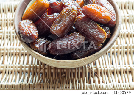 Fresh dates Medjul in a wooden bowl right corner 33200579