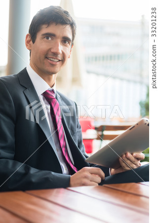 Young man wearing business suit while using a 33201238