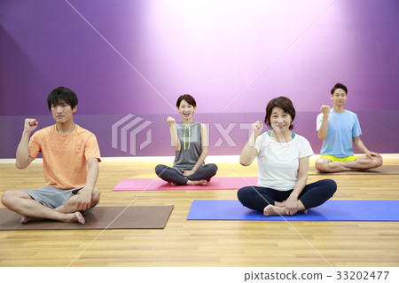 Men and women stretching in a sports club studio Men and women stretching in a sports club studio 33202477