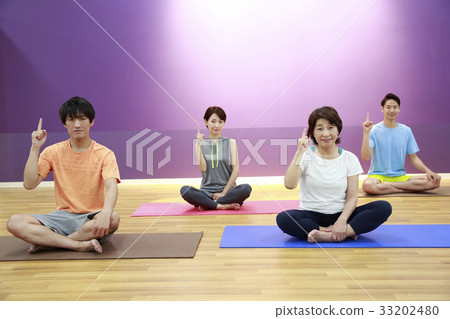 Men and women stretching in a sports club studio Men and women stretching in a sports club studio 33202480