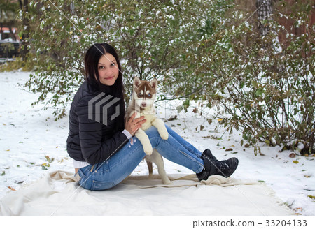 portrait of a young women with a husky puppies 33204133