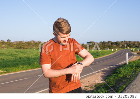 Male runner jogging outside looking at his 33205088