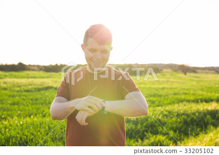 Close-up of Male runner jogging outside looking at 33205102