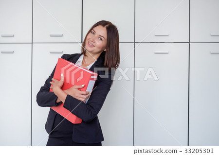 Happy young businesswoman holding a red binder And 33205301