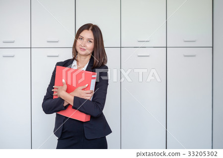 Happy young businesswoman holding a red binder And 33205302