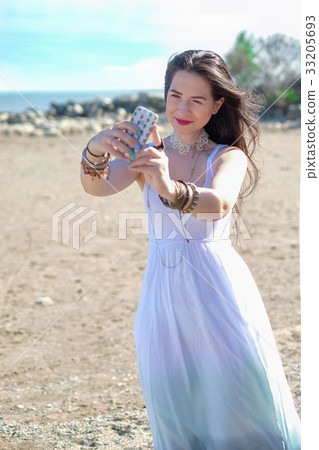 Young woman is photographing herself on the phone Young woman is photographing herself on the phone 33205693