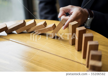 businessman hand stop dominoes continuous toppled or risk with c businessman hand stop dominoes continuous toppled or risk with c 33206582