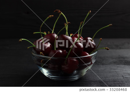 Cherry in a glass plate on a black background 33208468
