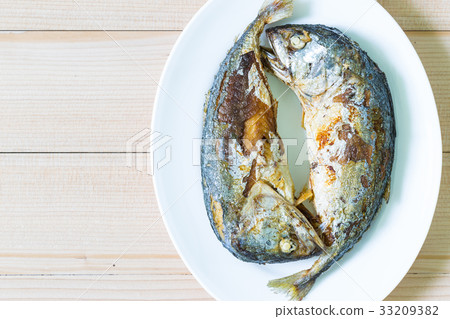 Fried two short mackerel fishes on wooden floor Fried two short mackerel fishes on wooden floor 33209382