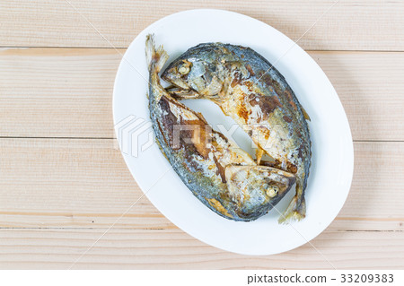 Fried two short mackerel fishes on wooden floor Fried two short mackerel fishes on wooden floor 33209383