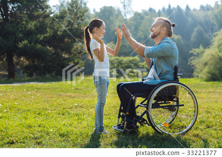 Young father with mobility impairment high-fiving Young father with mobility impairment high-fiving 33221377