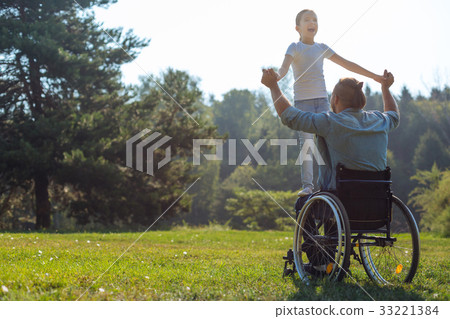 Mobility-impaired father holding his daughter on Mobility-impaired father holding his daughter on 33221384