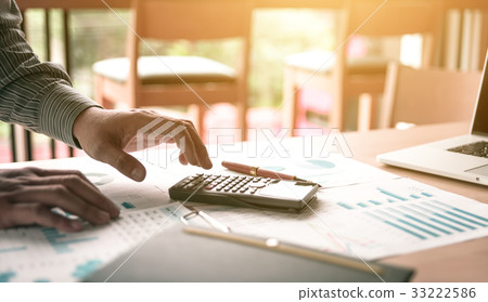 Businessman standing and using calculator Businessman standing and using calculator 33222586