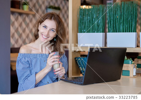 Businesswoman Working On Laptop In Coffee Shop Businesswoman Working On Laptop In Coffee Shop 33223785