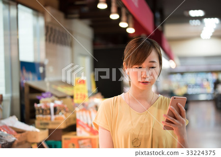 Young housewife shopping in supermarket 33224375