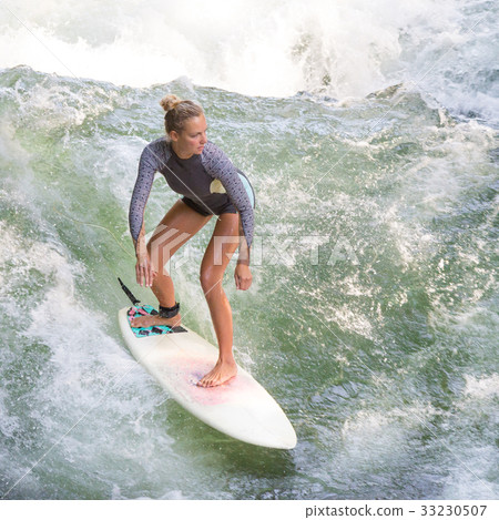 Atractive sporty girl surfing on famous artificial Atractive sporty girl surfing on famous artificial 33230507