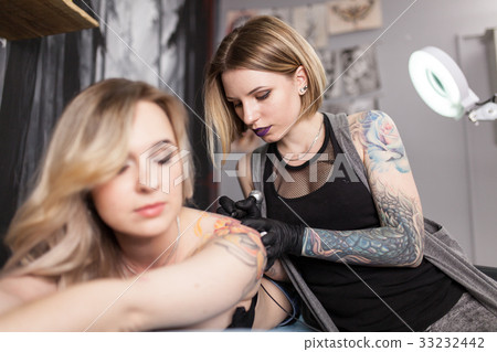 Tattoo artist in a studio Tattoo artist in a studio 33232442