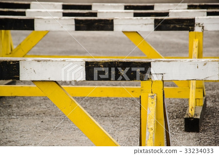 A hurdle race on gray running in stadium track A hurdle race on gray running in stadium track 33234033