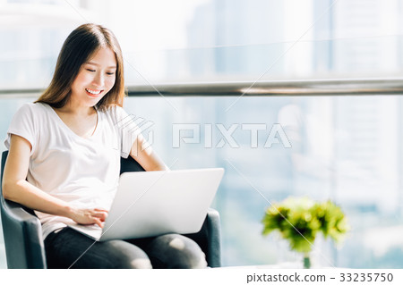 Cute Asian girl happy working on laptop computer Cute Asian girl happy working on laptop computer 33235750