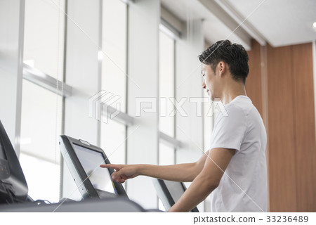 Men starting a running machine 33236489