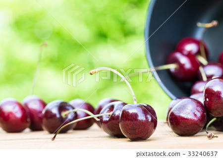 Cherries on wooden table with green background 33240637